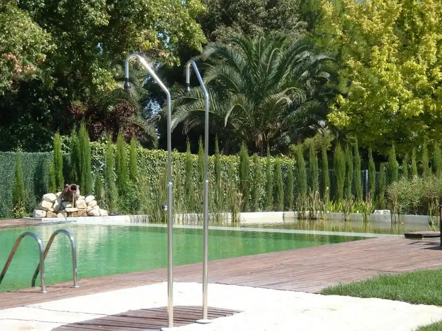 Outdoor swimming pool surrounded by mature gardens